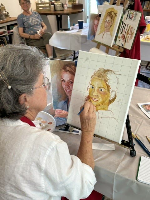 An artist working at an easel during a drawing session