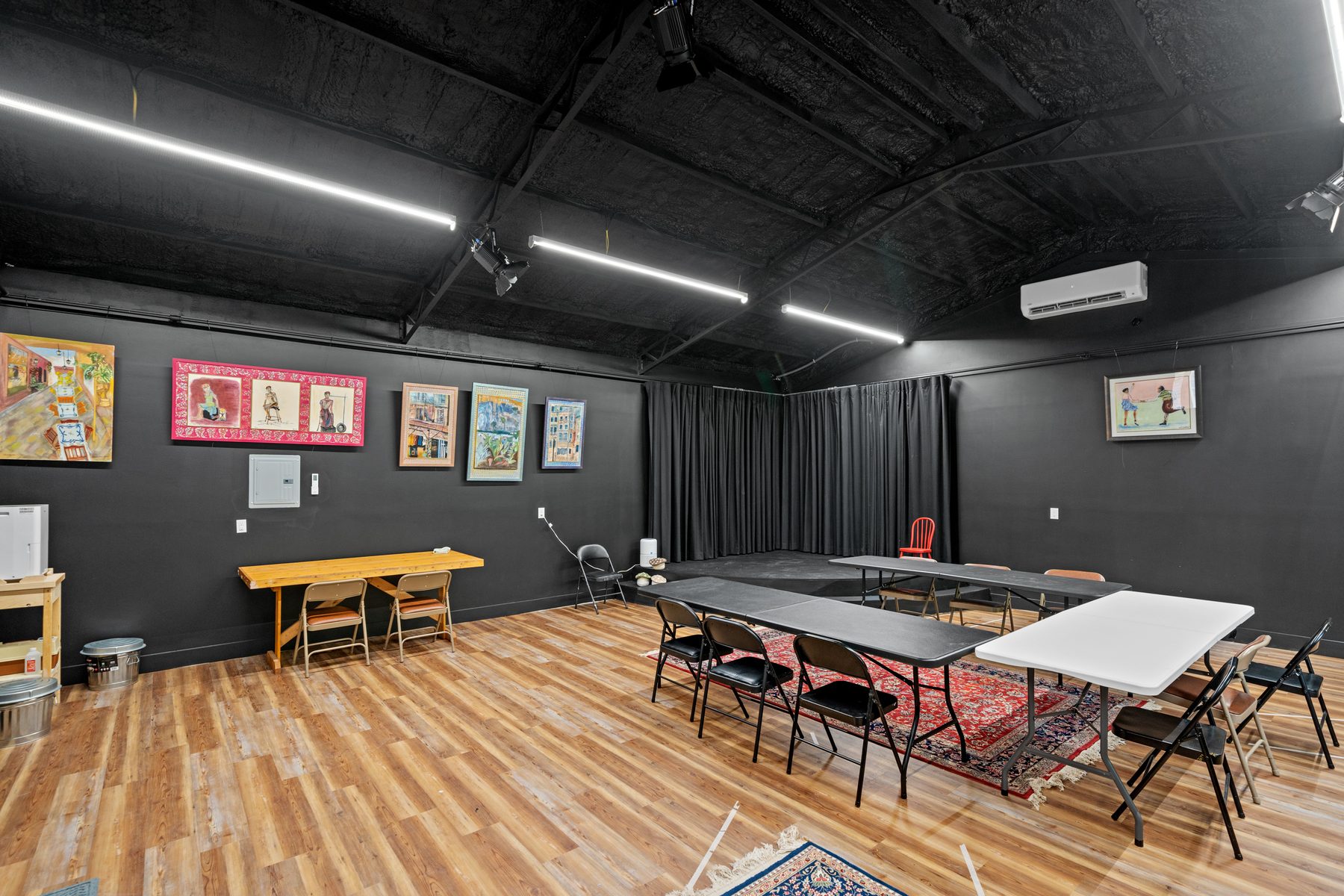 The black box theater set up with tables and chairs for a workshop.