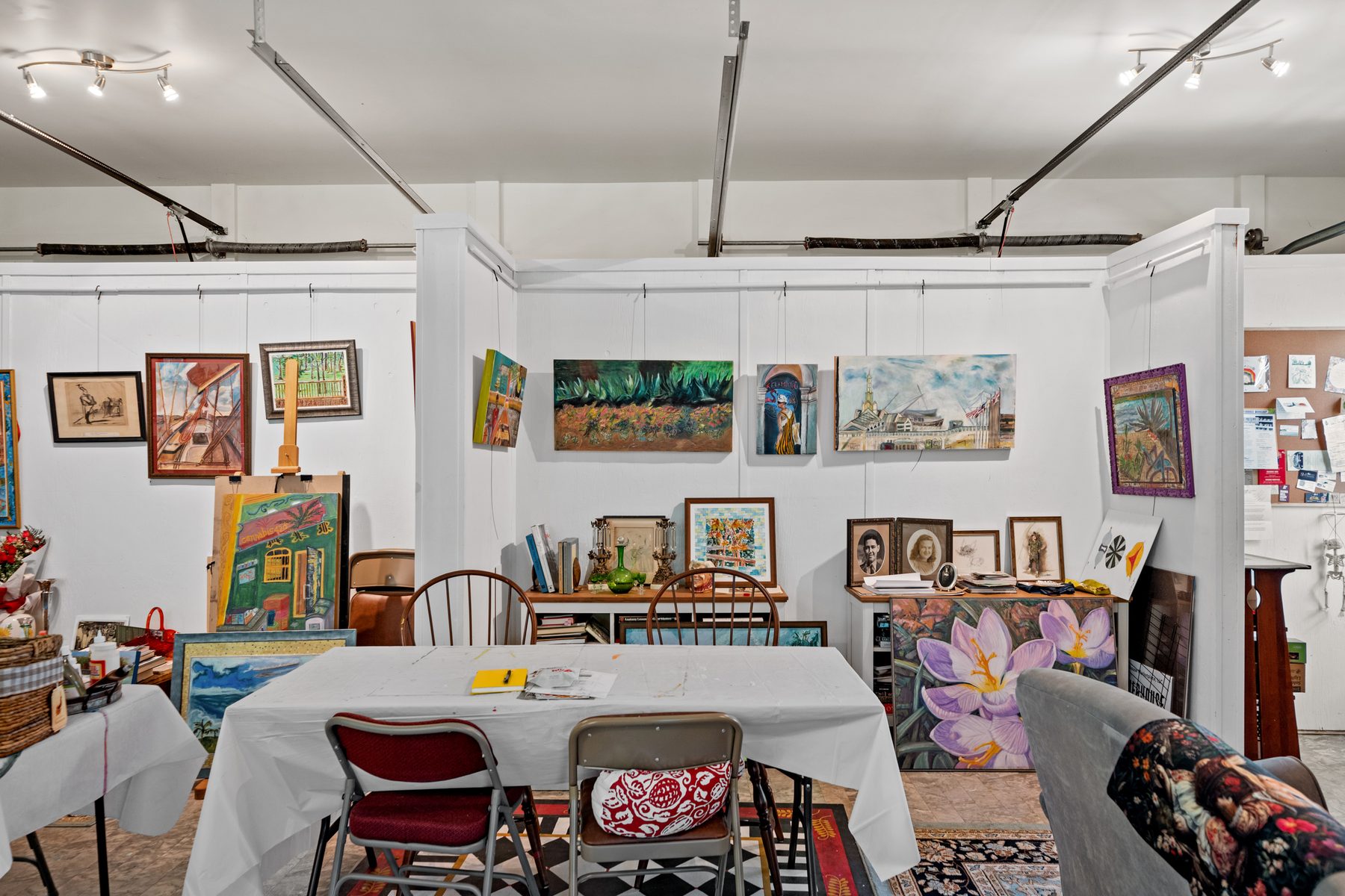 The painting studio, work hung on every wall and a long table laid out ready for a class