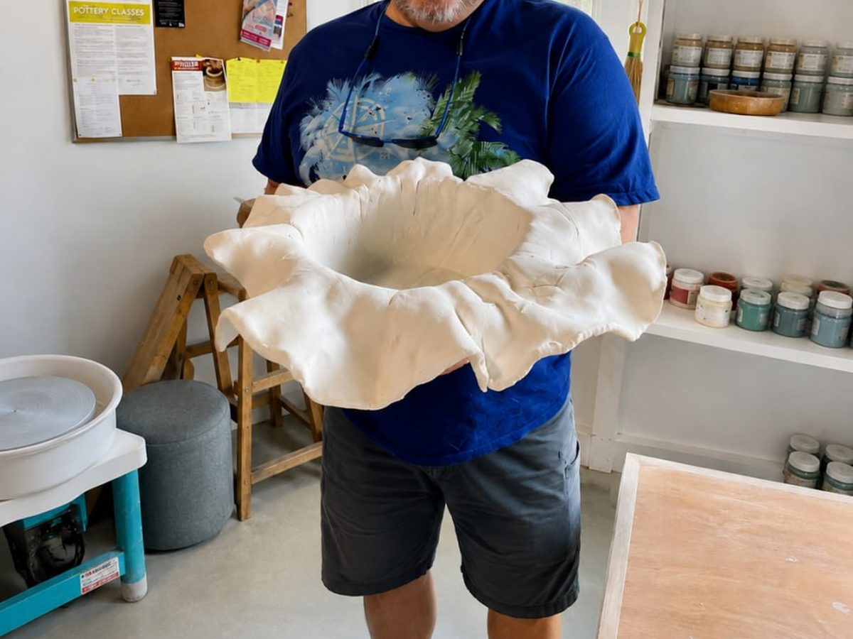 Hands working clay on the studio table at Riverhouse Create