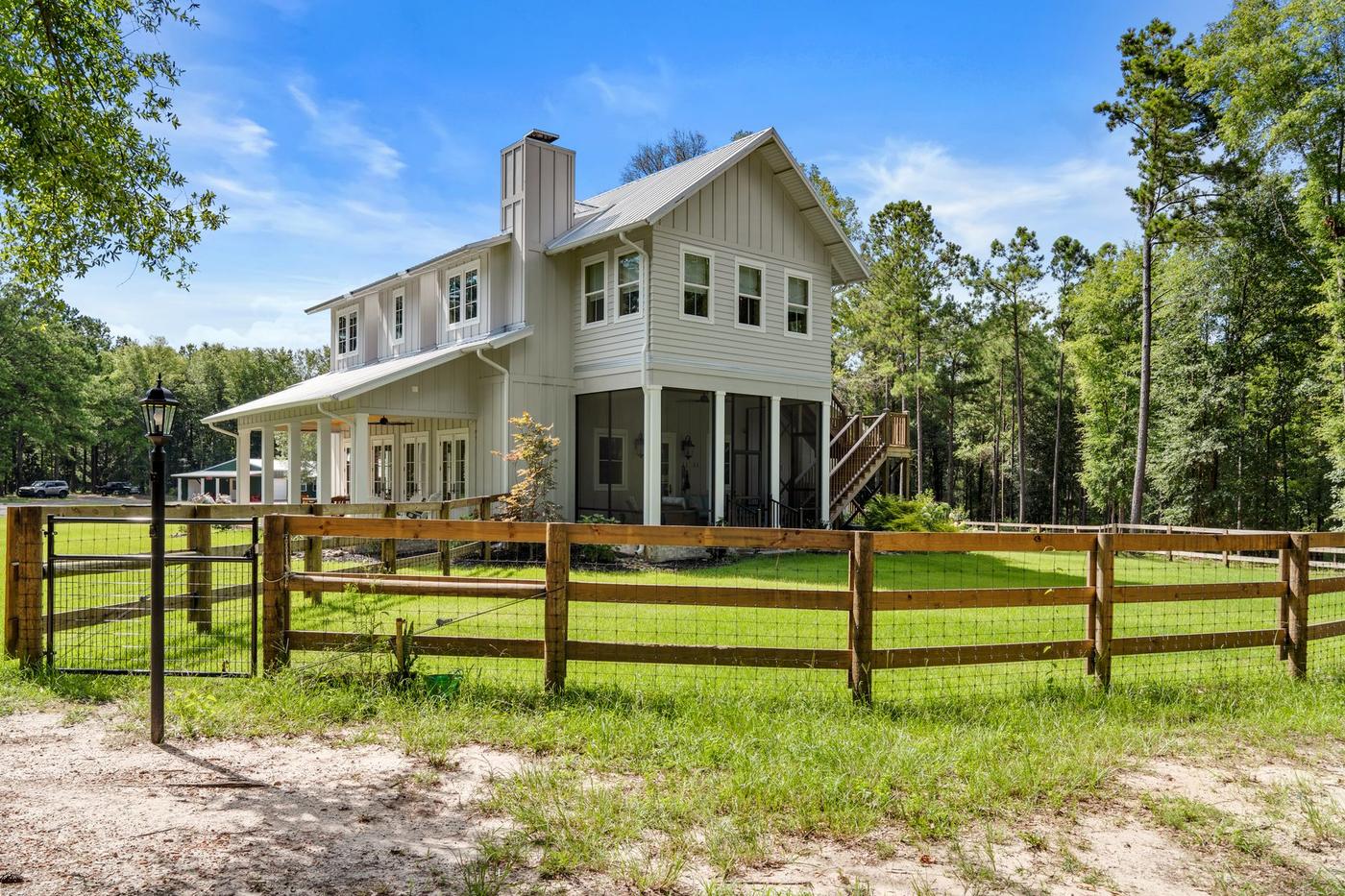 The Riverhouse Create building behind its fence, pines on both sides