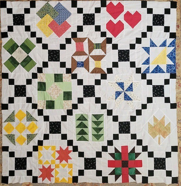 A sampler quilt of pieced blocks, every one a different pattern.