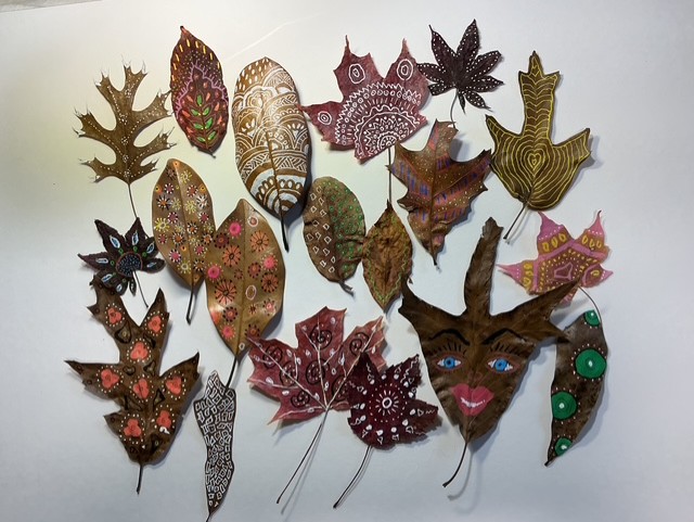 Painted dried leaves arranged on a white background.