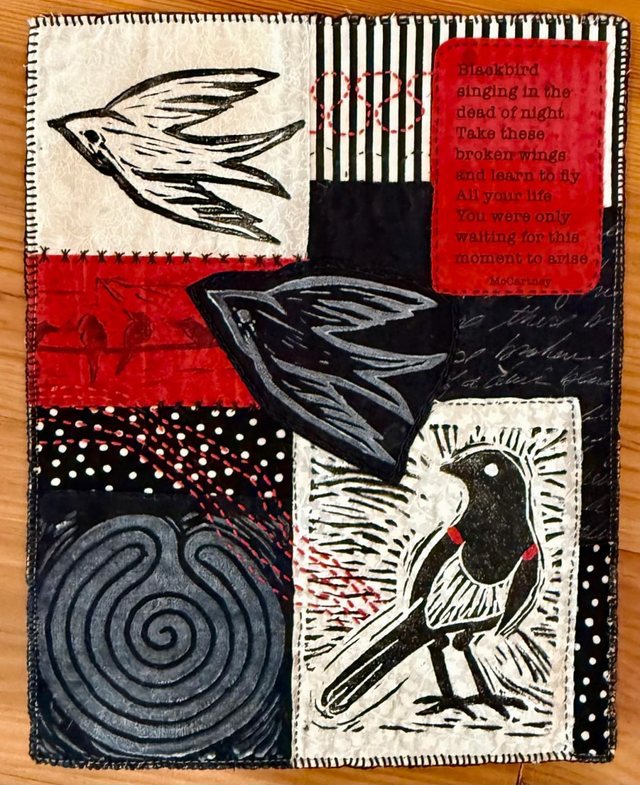 A stitched and printed textile panel of blackbirds, with a verse worked into one corner.