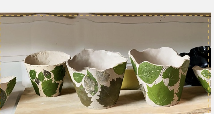 Pale clay vessels printed with green leaf impressions