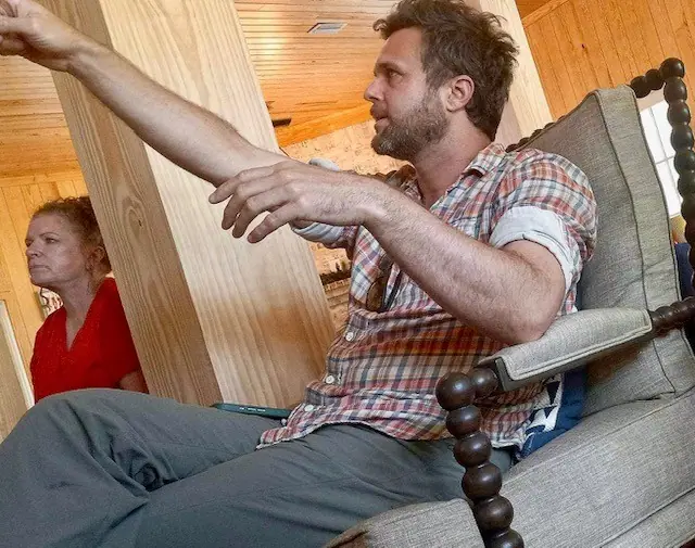 A man gestures animatedly while telling a story in the lodge