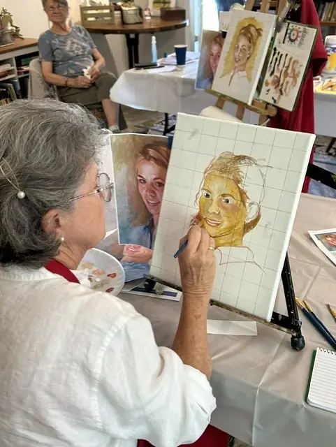 A student sketches a portrait during a life drawing class