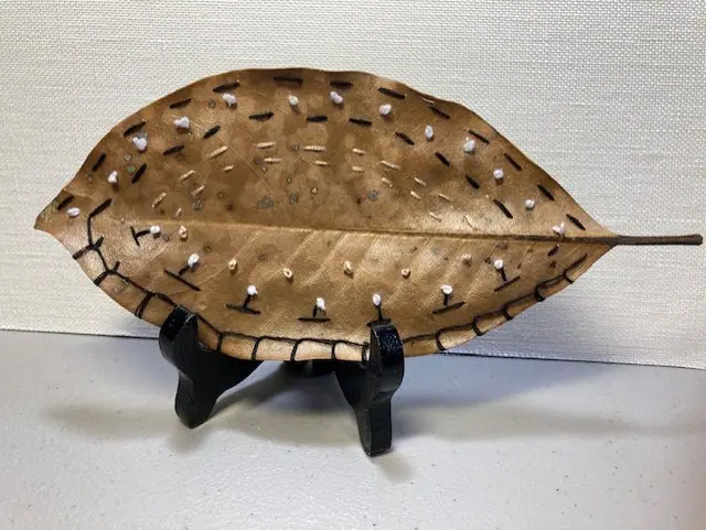 A spotted ceramic leaf dish on a stand
